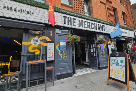 Exterior image of The Merchant in Brentwood.  Two flags for football clubs are visible at the front.