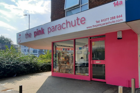 Image showing the front of 'the pink parachute' on the corner of Ongar Road, Brentwood.  The building is painted pink, while the signage is white with pink lettering.  The sign also has 14a, printed on it, and the words 'Tel: 01277 288844' and 'www.thepinkparachute.com'.