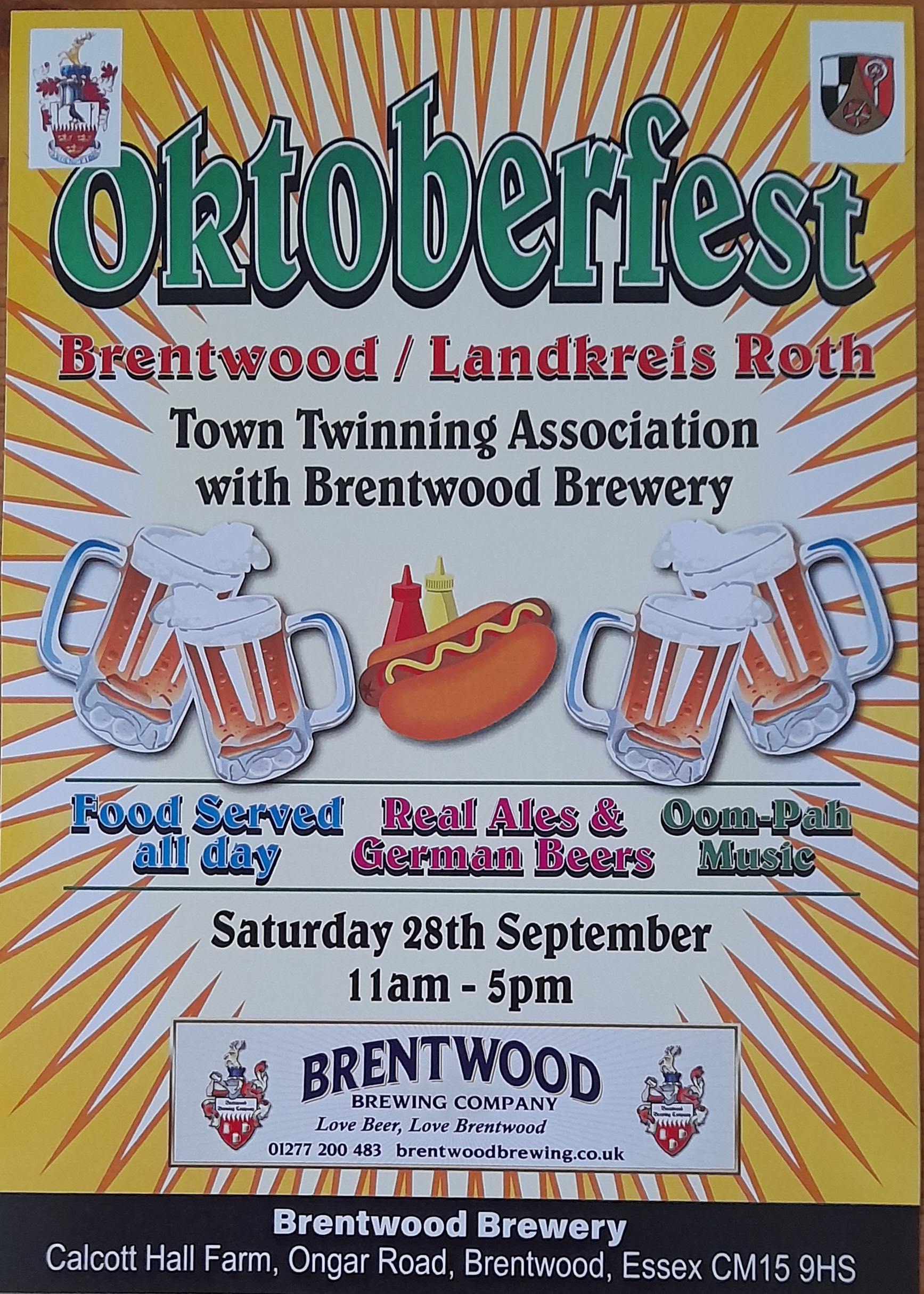 The image is a poster for an Oktoberfest event. The main text reads:  "Oktoberfest Brentwood / Landkreis Roth" "Town Twinning Association with Brentwood Brewery"  Below this, there are graphics of beer mugs, a hot dog with mustard and ketchup bottles, and more beer mugs. The text around the graphics says:  "Food Served all day" (in blue text) "Real Ales & German Beers" (in red text) "Oom-Pah Music" (in green text) Further down, the details of the event are provided:  "Saturday 28th September 11am - 5pm"