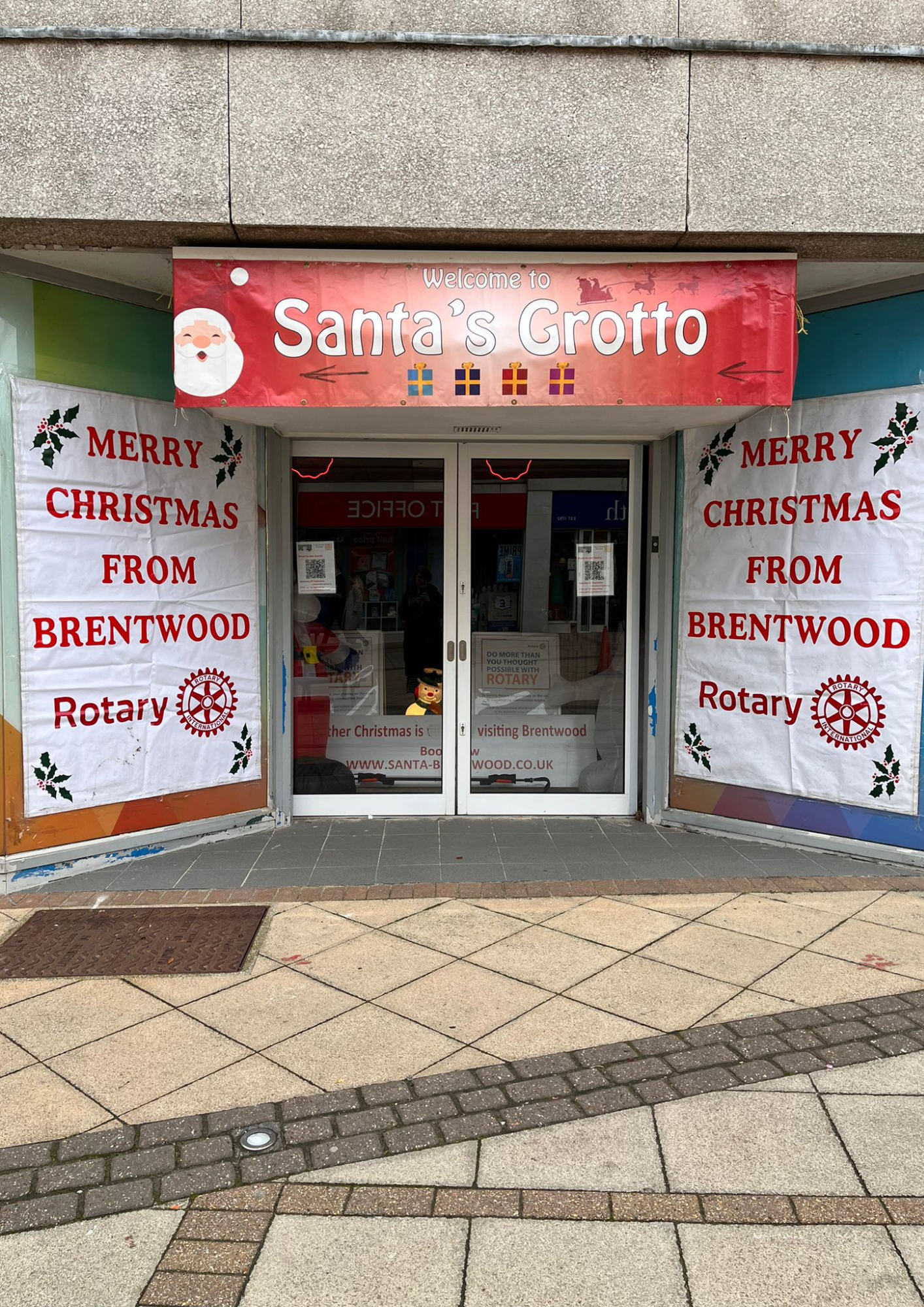 Image showing Santa's Grotto entrance, from the Rotary Club of Brentwood,with festive banners on either side.  Signage reads 'MERRY CHRISTMAS FOM BRENTWOOD ROTARY'.