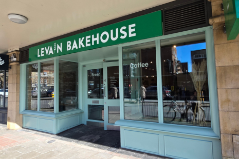 Image showing the exterior of Levain Bakehouse, painted pale blue with a green sign.