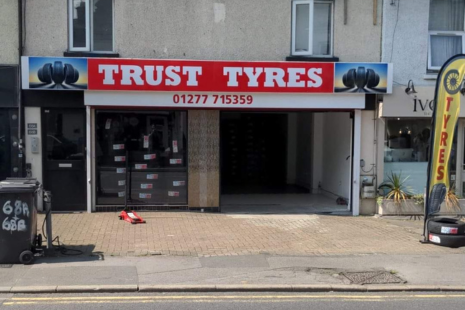 Image of the exterior of 'TRUST TYRES' on Ongar Road.  Shows a selection of tyres on display in the window.