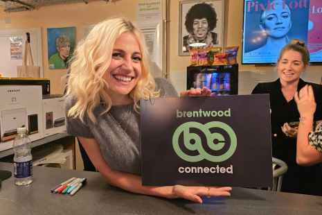 Image showing Pixie Lott holding a 'Brentwood Connected' sign at Hey Joe Music & Coffee in Brentwood