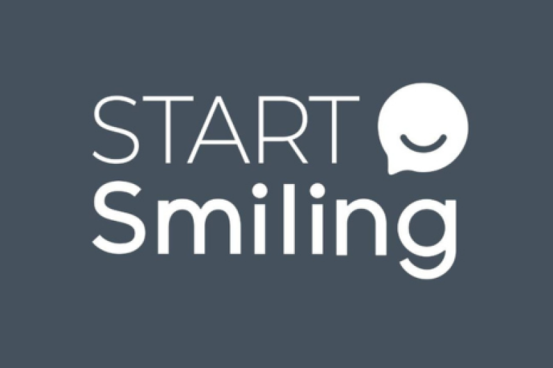 Logo for 'START Smiling', white text on blue/grey background.  White smiling icon.