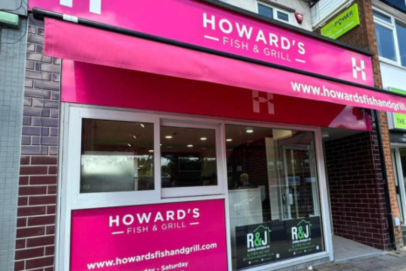 Image of the exterior of Howard's Fish & Grill, with pink signage at the top and bottom and pink awning with white text.