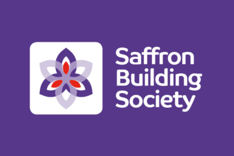 Logo for Saffron Building Society with white text on a purple background and a saffron flower in light and dark purple and pink.