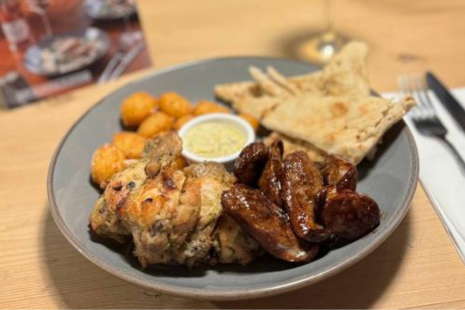 A plate of chicken wings, dip, pitta and nuggets