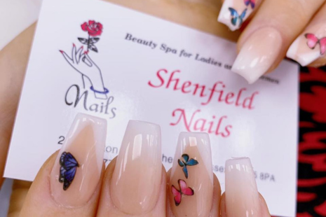 Image of manicured nails with butterflies holding a white business card for Shenfield Nails, with pink text and a hand-drawn image of a hand holding a red flower