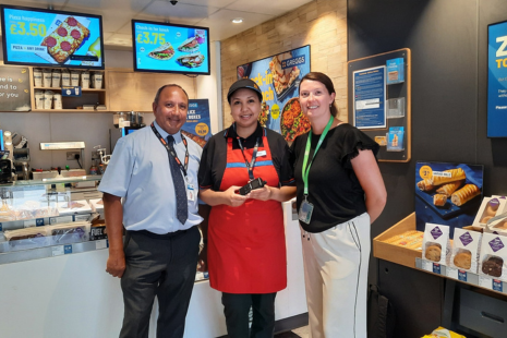 Image showing PC Alex Plakhtienko, of Essex Police’s specialist Business Crime Team, Rianna from Greggs wearing an orange apron and holding a TownLink radio, with Sarah Walmsley, Brentwood Connected Business Improvement District (BID) Manager and a Greggs store.