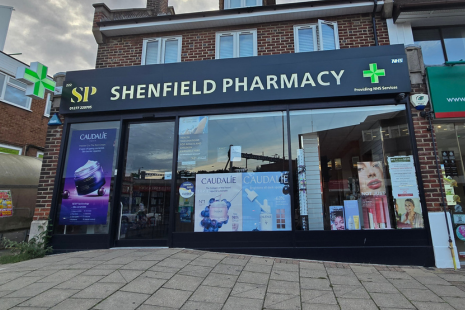 Image showing the exterior of Shenfield Pharmacy with black signage, white text, and a green + symbol.